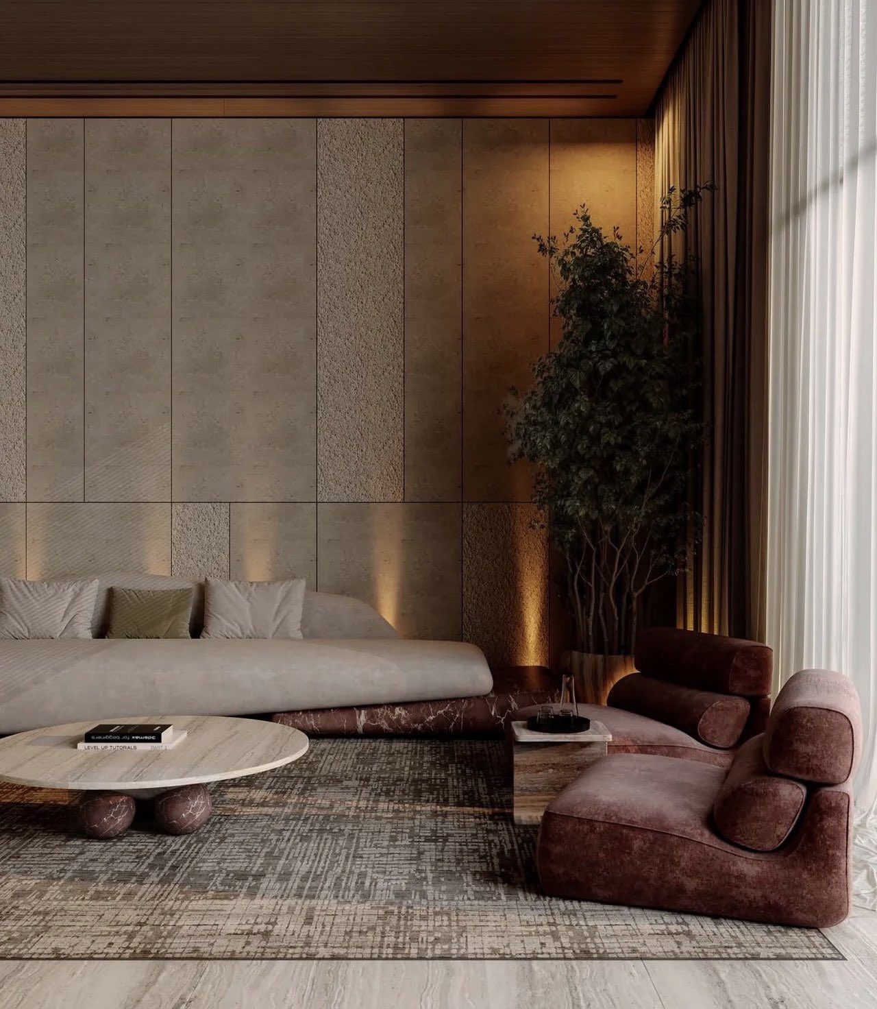 A living room furnished with a low grey Attik sofa, burgundy lounge chairs and a round travertine coffee table
